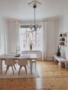 a white dining room with a table and chairs at Renovated Georgian esque style apartment in Malmö