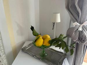 un tazón de limones y una planta sobre una mesa en A CASA DEL CONSOLE, en Mondello
