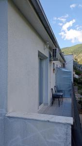 a patio with a table and chairs on a balcony at Apartmani Stolac in Stolac