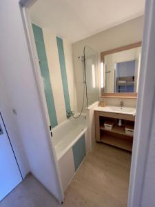 y baño con bañera, lavabo y espejo. en Appartement 4 Personnes dans Résidence Golf de Valescure 2, en Saint-Raphaël