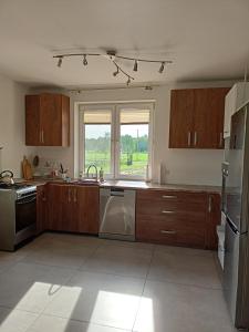 a kitchen with wooden cabinets and stainless steel appliances at U Stasia in Uścimów