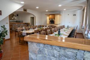 a dining room with tables and chairs and a bar at Apartma Valič in Ajdovščina