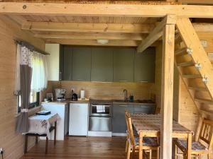 a kitchen with white appliances and a table with chairs at Oaza Marcinkowska in Purda