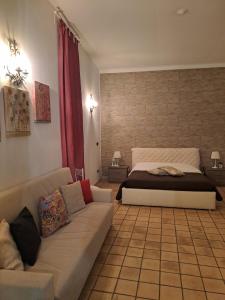 sala de estar con cama y sofá en Appartamento Dammuso Isola Di Ortigia, en Siracusa