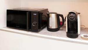 a microwave and a coffee maker on a shelf at Apparemment t3 au cœur champenois in Charly-sur-Marne