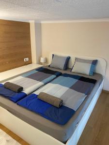 uma cama grande com lençóis e almofadas azuis e brancos em Anna Apartman em Csopak