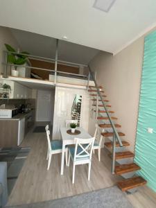 um quarto com uma mesa e cadeiras e uma escada em Anna Apartman em Csopak
