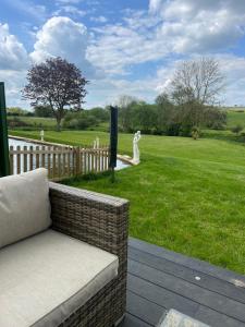 eine Couch auf einer Veranda mit Blick auf einen Hof in der Unterkunft The Rutland House South Luffenham in Oakham