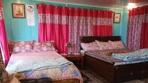 een slaapkamer met 2 bedden en rode gordijnen bij Lebong Mansara Homestay in Darjeeling