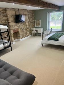 a room with two beds and a stone fireplace at The Rutland House South Luffenham in Oakham