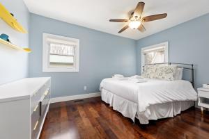 una camera da letto con pareti blu e un letto con ventilatore a soffitto di Green Lake Central Cottage a Interlochen