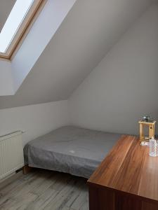 een slaapkamer met een bed en een houten vloer bij U Stasia in Uścimów