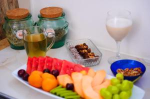 a plate of fruit and vegetables and a glass of wine at צימר - על פלגי מים in Menaẖemya +16 photos