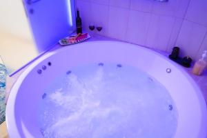 a white bath tub in a bathroom with aiolet at צימר - על פלגי מים in Menaẖemya