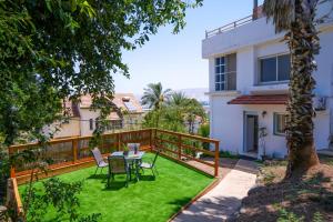 a balcony with a table and chairs in a yard at צימר - על פלגי מים in Menaẖemya