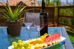 a table with a plate of fruit and wine glasses at צימר - על פלגי מים in Menaẖemya