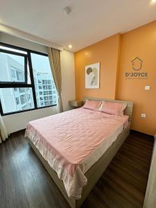 a bedroom with a bed with pink sheets and a window at JOYCE-Celia 34 in An Khê