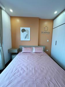 a bedroom with a large bed with pink sheets at JOYCE-Celia 34 in An Khê