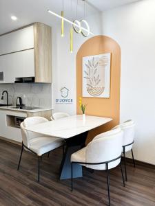 a dining room with a white table and chairs at JOYCE-Celia 34 in An Khê