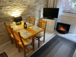 a dining room with a table and a fireplace at Cosy 2 pièces proche Châtel in Abondance