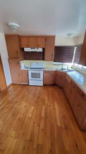 una cucina con pavimenti in legno e stufa bianca di Pearl Cove a Santa Cruz
