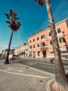 a street with two palm trees and a building at Apartment #Story in Koper