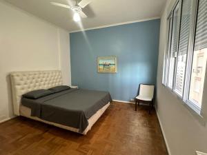 une chambre avec un lit et un ventilateur de plafond dans l'établissement Hermoso dpto con vista frontal al Mar Pitangueiras, à Guarujá