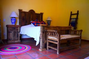 a bedroom with a bed with a wooden headboard and a table at Hermosa Casa de Campo muy cerca de Guadalajara in Tlajomulco de Zúñiga