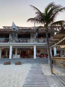 a palm tree in front of a building at Punta Blanca Beach House in Costa Mujeres