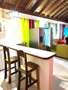 a kitchen with a counter with two chairs and a refrigerator at Golden View in St Mary