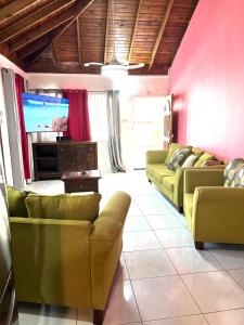 ein Wohnzimmer mit 2 Sofas und einem Flachbild-TV in der Unterkunft Golden View in Saint Mary
