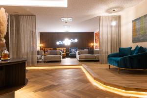 una sala de espera con sofás y sillas en una habitación en Grandhotel Lienz Business-Wellness & Gourmet, en Lienz