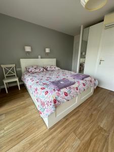 a bedroom with a bed with a floral comforter and a mirror at Villa MA&VA in Lacanau-Océan