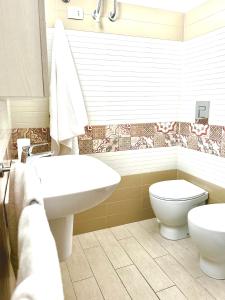 bagno con lavandino bianco e servizi igienici di Appartamenti Sul Mare ad Avola
