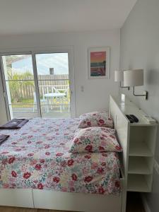 a bedroom with a bed and a desk and a window at Villa MA&VA in Lacanau-Océan