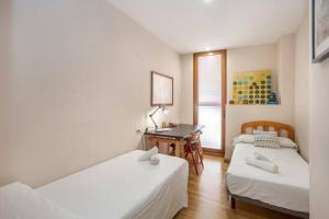 Habitación de hotel con 2 camas y escritorio en Marieta Apartment by The Castle with AC, en Alicante