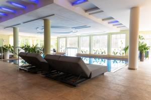 a lobby with chairs and a swimming pool at Grandhotel Lienz Business-Wellness & Gourmet in Lienz