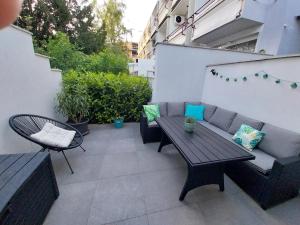 a patio with a couch and a table and chairs at Anna Apartman in Csopak