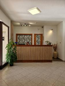 a person sitting at a reception desk in a lobby at Hotel Mistral in Alghero