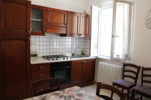 kuchnia z drewnianymi szafkami, kuchenką i oknem w obiekcie Appartamenti Sirolo 60020 w mieście Sirolo