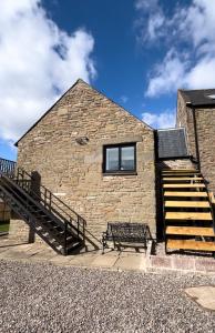 - un bâtiment en pierre avec un banc et un escalier dans l'établissement Corn Flour Lodge, à Dundee