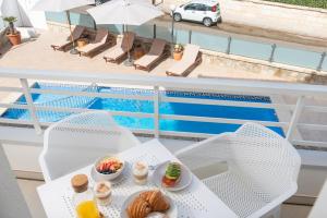 una mesa con comida junto a una piscina en Bauló Mar Apartments, en Can Picafort