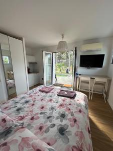 a bedroom with a bed with a floral bedspread at Villa MA&VA in Lacanau-Océan
