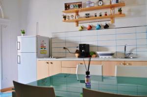 a kitchen with a glass table and a refrigerator at Gaia Holiday House in Vietri sul Mare +4 photos