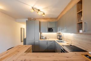 uma cozinha com armários cinzentos e um balcão de madeira em BNB Slovakia Guthaus 64D em Bratislava