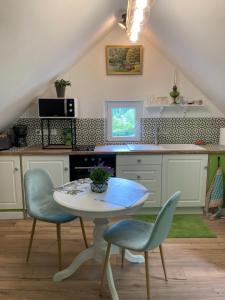 a kitchen with a table and chairs in a kitchen at Un Amour de Grenier,à 200m du Zoo in Saint-Aignan
