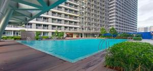 a large swimming pool in front of a building at The ICONIC: Comfortable living by Awsom Phil in Manila