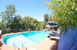 - une piscine bordée de chaises et de parasols dans l'établissement Ferienhaus mit Privatpool für 8 Personen ca 180 qm in Massarosa, Toskana Provinz Lucca, à Massarosa