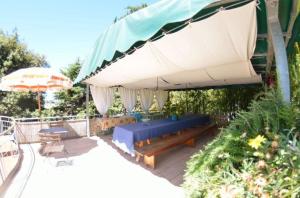 une terrasse avec un banc et un grand parasol dans l'établissement Ferienhaus mit Privatpool für 8 Personen ca 180 qm in Massarosa, Toskana Provinz Lucca, à Massarosa