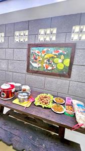 a table with plates of food and a painting on a wall at Omah Tabon Jogja - Dekat Dengan Malioboro in Timuran
